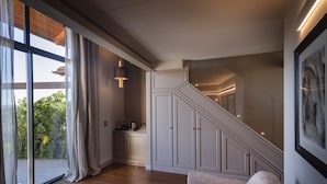 A modern interior with a staircase, wooden flooring, and a seating area.