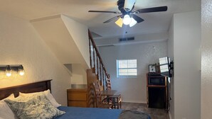 A bedroom with a bed, a desk, and a ceiling fan. - Room 1- Historic Little Switzerland (Jasper)