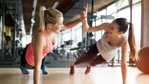 Two people doing push-ups in a gym with exercise equipment in the background. - Gold Standard Caravan - SOUTH VIEW PARK (Skegness)