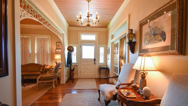 A cozy living room with a chandelier, a framed picture, and a wooden coffee table.