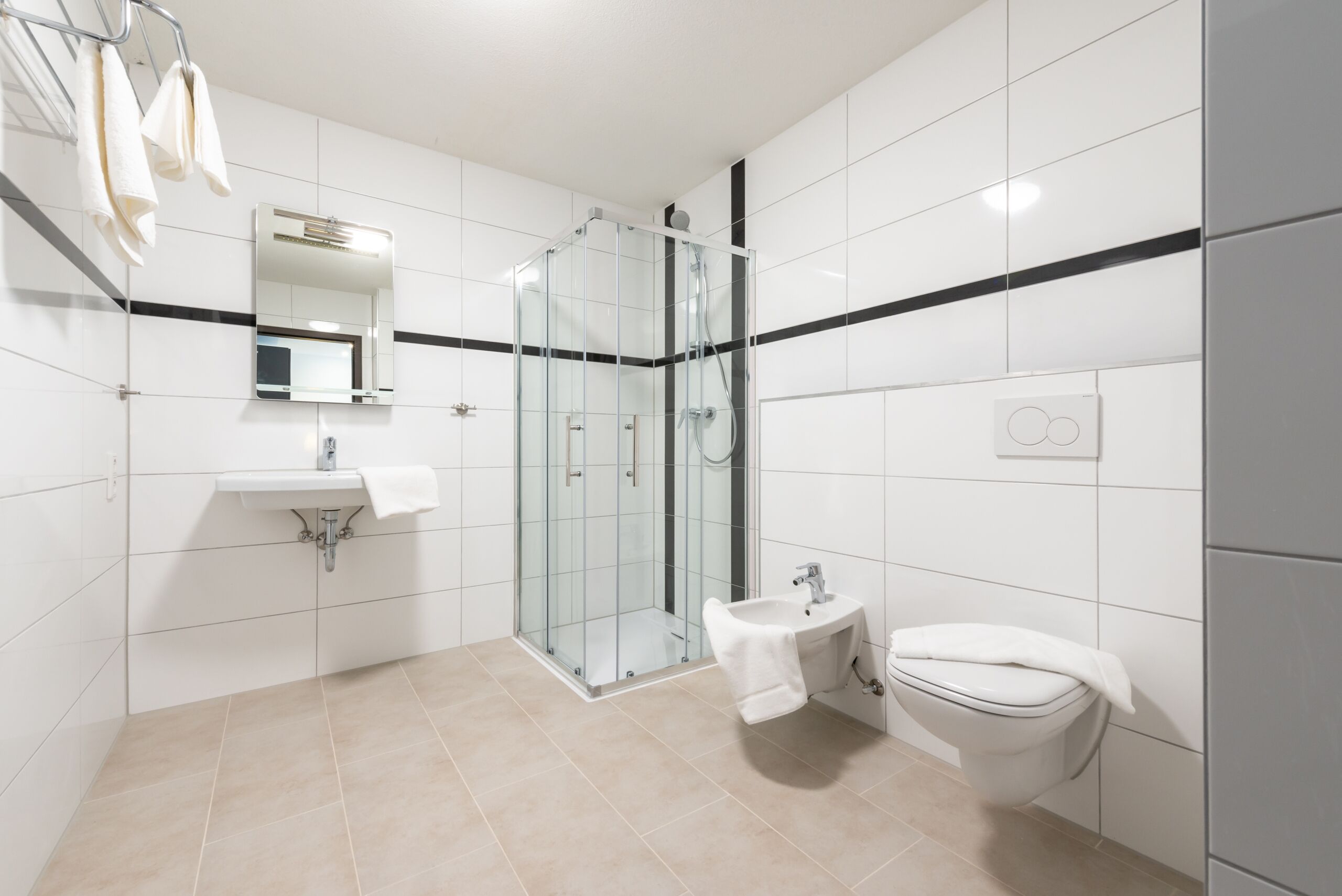 A modern bathroom with a glass-enclosed shower, a sink, and a toilet.