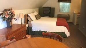 A bedroom with a bed, dresser, vanity, and a small table. - Historical Little Switzerland - Room 5 (Jasper)