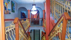 Una escalera con barandillas de metal ornamentadas y un candelabro.