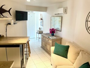 A compact living space with a dining area, a kitchenette, and a seating area with a couch.