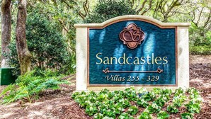 A sign for Sandcastles Villas 255-329, surrounded by greenery. - Breathtaking View of the Atlantic Ocean & Beach (Fernandina Beach)