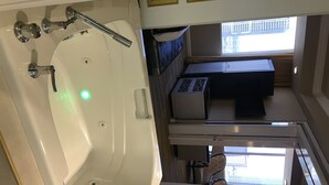 Une salle de bain avec une baignoire, des toilettes, un lavabo et une fenêtre.