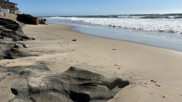 A beach with a rocky shoreline, clear sky, and waves approaching the shore. - Exquisite L.B. House Within Walking Distance to Beach and Town (Laguna Beach)