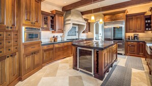 A spacious kitchen with wooden cabinets, a central island, and modern appliances. - Soquel Villa - 180 views of Monterey Bay w/ infinity pool, spa & movie theater (Soquel)