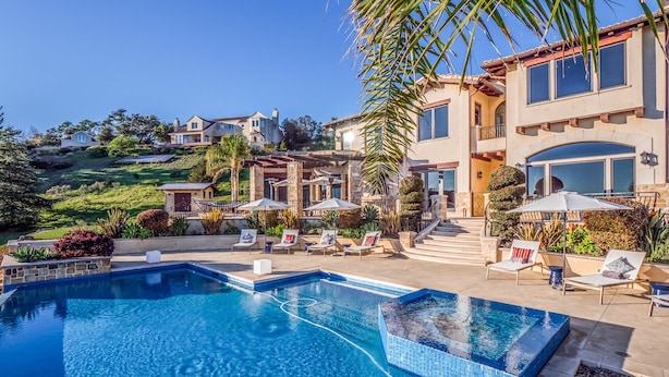 A swimming pool with a tiled edge, surrounded by lounge chairs and umbrellas. - Soquel Villa - 180 views of Monterey Bay w/ infinity pool, spa & movie theater (Soquel)