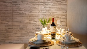 A table set for a meal with a bottle of Servado wine, plates, glasses, and a candle.