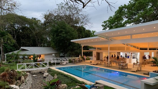 A modern outdoor pool area with lounge chairs, a bar, and a covered seating area. - Aves Hotel & Resort - Retreat Center (Cóbano)