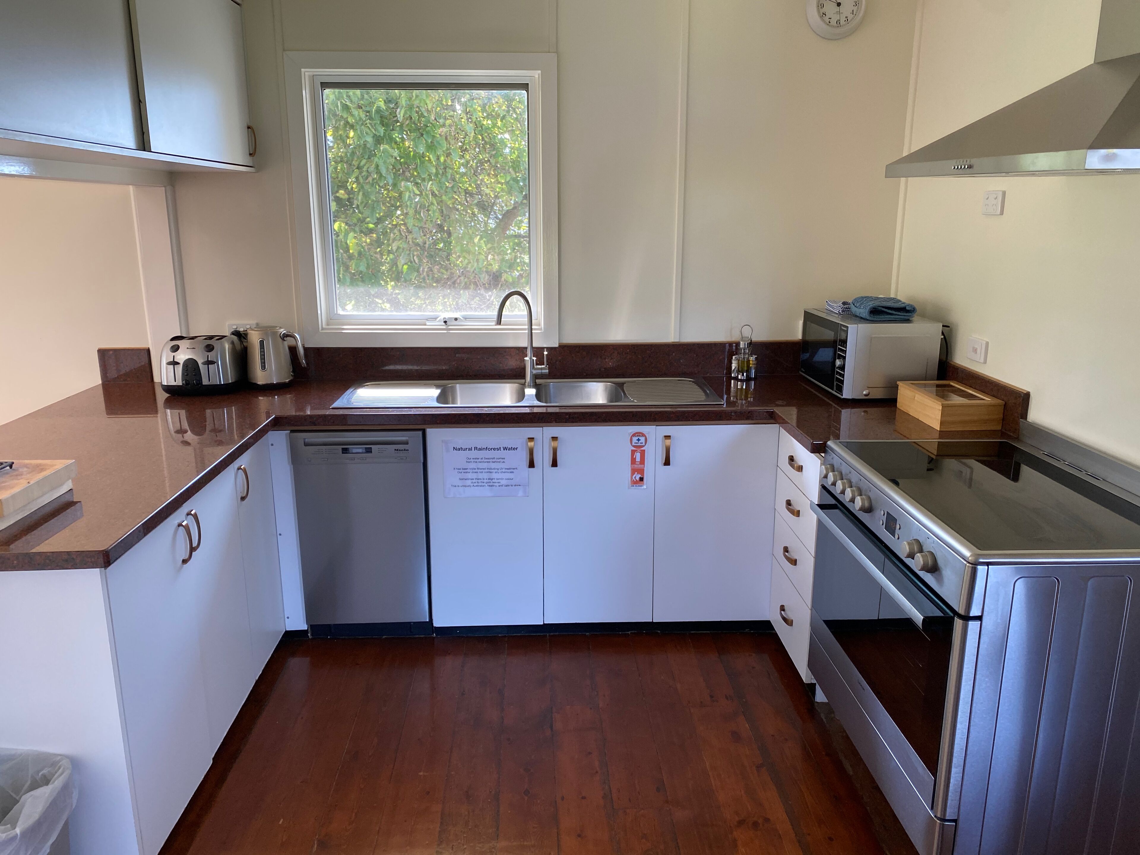 A modern kitchen with a dishwasher, sink, microwave, and stove.