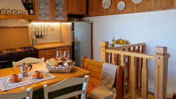 A cozy kitchen with wooden cabinets, a refrigerator, a dining table with chairs, and a bench.