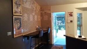 Una cocina con encimera oscura, dos taburetes de bar y un salpicadero con diseño.