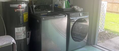 A laundry area with a washing machine, dryer, and a water heater.