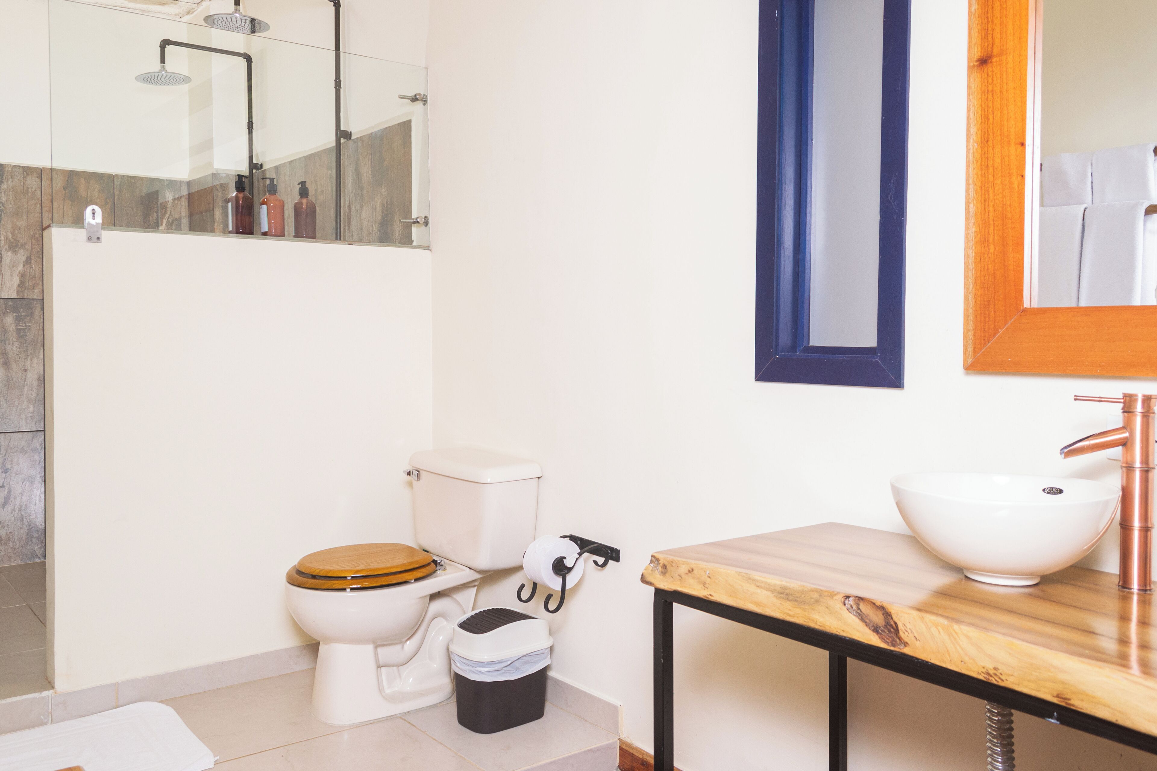 Een moderne badkamer met toilet, wastafel en douche.