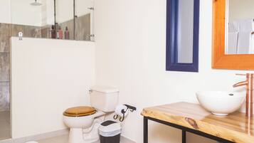 Un baño moderno con inodoro, lavamanos y ducha.