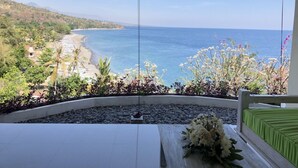 A balcony with a view of a beach and ocean. - Waenis Sunset View (Karangasem)