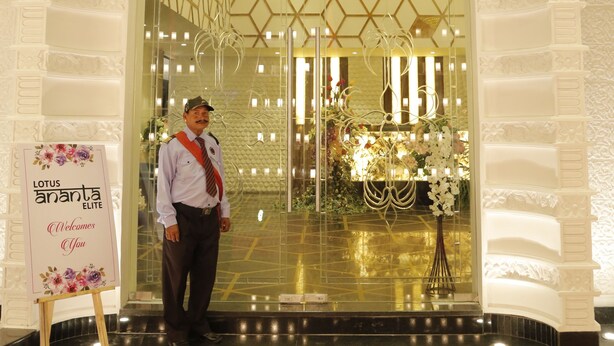 A hotel entrance with a grand archway, a reception desk, and a floral welcome sign. - Lotus Ananta Elite Kota (Kota)