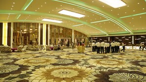 A spacious lobby with a patterned floor, high ceilings with recessed lighting, and a seating area with chairs and tables. - Lotus Ananta Elite Kota (Kota)