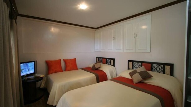 A hotel room with two beds, a TV, and a small desk. - Kamayan sa Palaisdaan Hotel and Resort (Tayabas City)