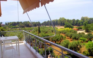 A balcony with a view of a green landscape, including trees and a distant mountain range. - Giota Rooms (Pineios)