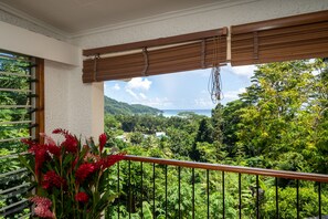 Un balcón con vistas a exuberante vegetación y colinas lejanas.
