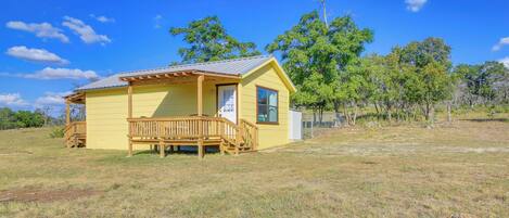 A yellow building with a wooden deck and a small porch.