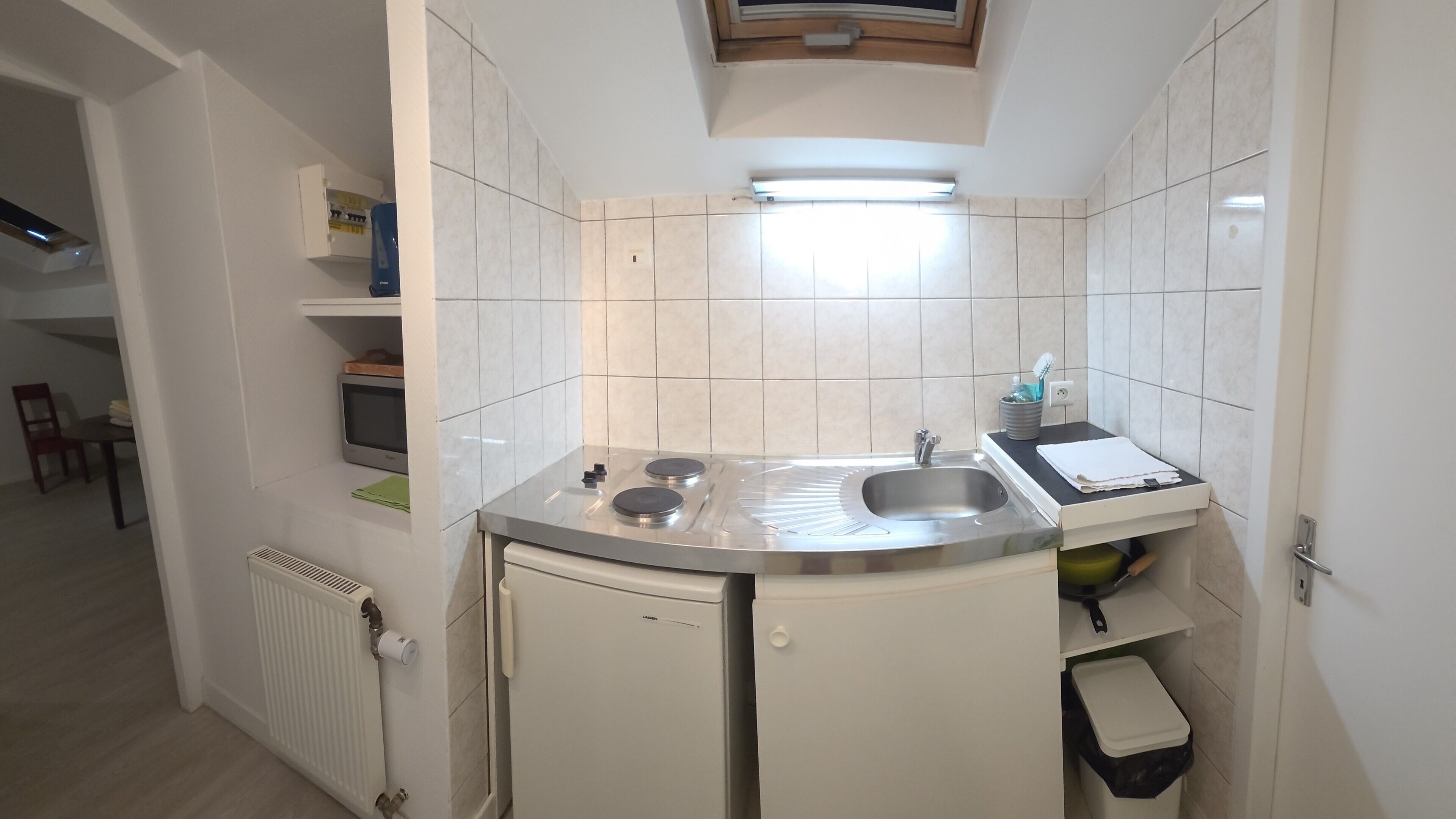 Cozinha compacta com fogão embutido, pia e armários.