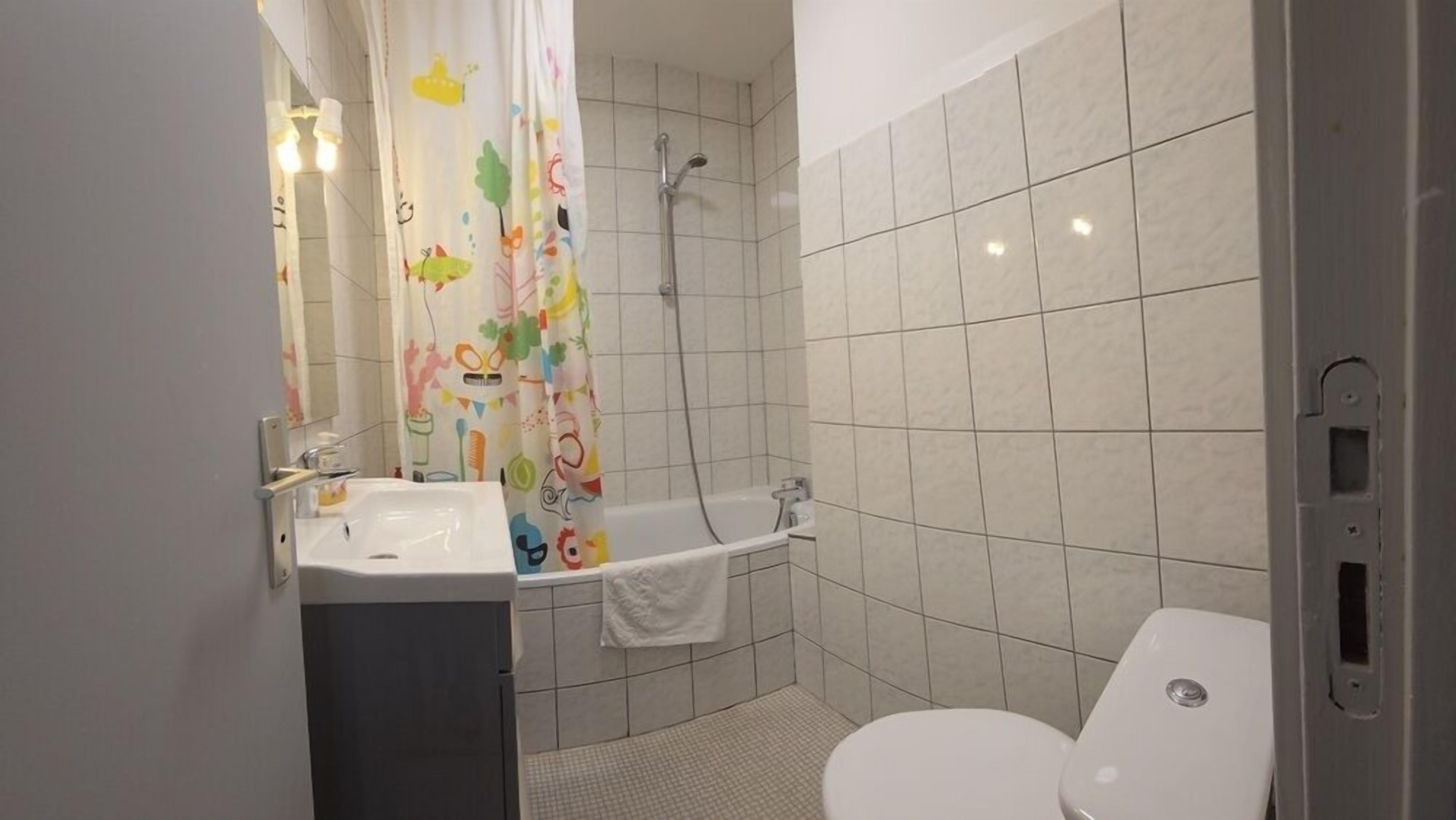 A bathroom with a shower, toilet, and sink.