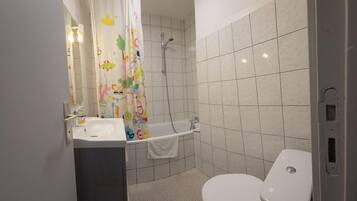 A bathroom with a shower, toilet, and sink.