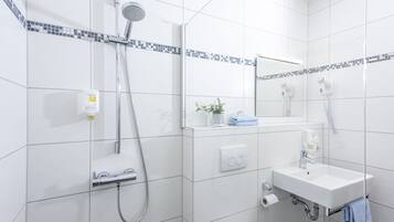 A modern bathroom with a shower, sink, and toilet.