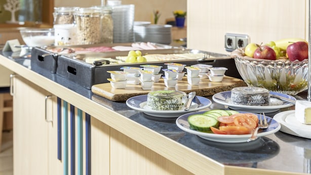 Tarjolla on runsas buffet, jossa on monenlaista ruokaa, kuten hedelmiä, vihanneksia ja erilaisia annoksia lautasilla.