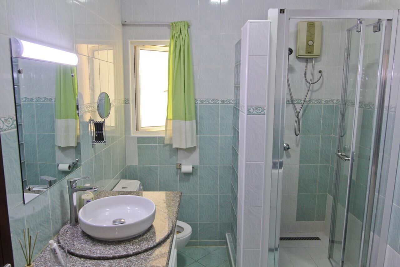 Ein Badezimmer mit Waschbecken, Spiegel, Toilette und Dusche.