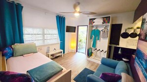 Een slaapkamer met een bed, een slaapbank, een kledingkast en een balkon.