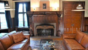 A room with a fireplace, leather sofas, and a dining table. - Architect's 3 Story Brownstone 4B4B Loring Heights (Minneapolis)