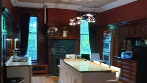 A kitchen with a central island, wooden cabinets, a built-in oven, and a large window. - Architect's 3 Story Brownstone 4B4B Loring Heights (Minneapolis)