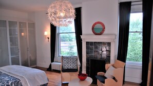 A bedroom with a bed, a fireplace, a dining table, and a chair. - Architect's 3 Story Brownstone 4B4B Loring Heights (Minneapolis)