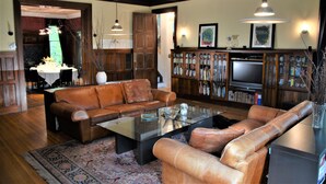 A living room with a brown leather sofa, a glass coffee table, a bookshelf, and a television. - Architect's 3 Story Brownstone 4B4B Loring Heights (Minneapolis)