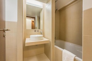 A bathroom with a white sink, mirror, and bathtub. - Salgados Beach Vila das Lagoas (Albufeira)