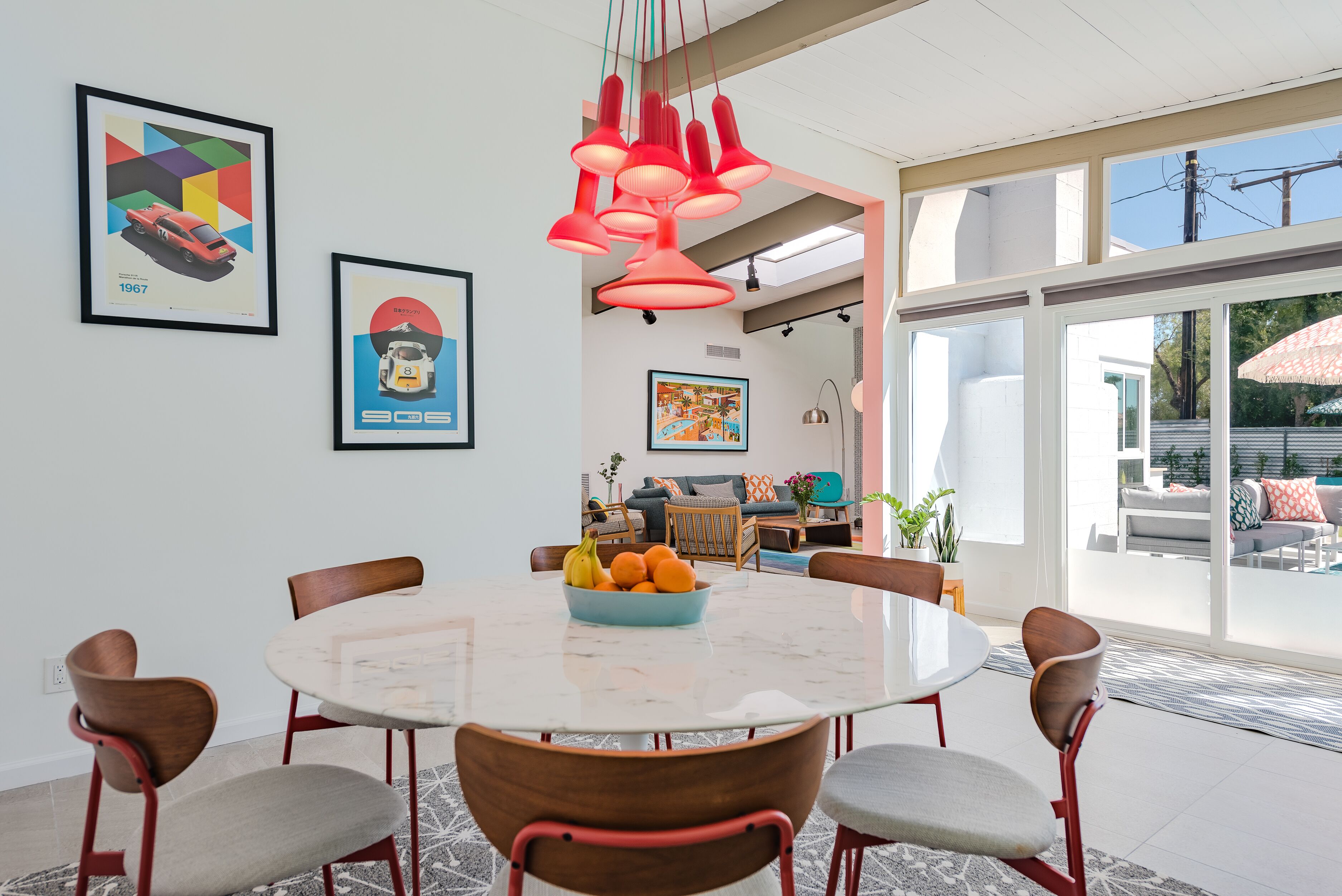 A modern dining area with a round table, chairs, and a fruit bowl.