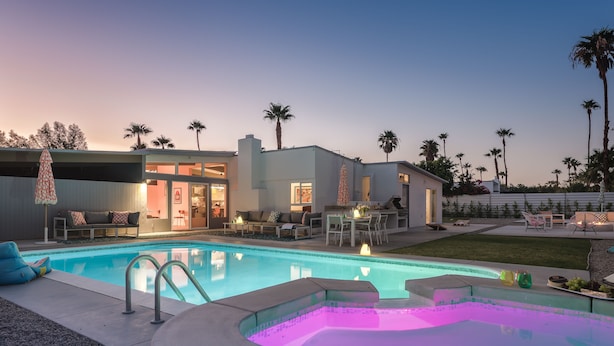 Una casa moderna con piscina, mobiliario de exterior y jacuzzi.