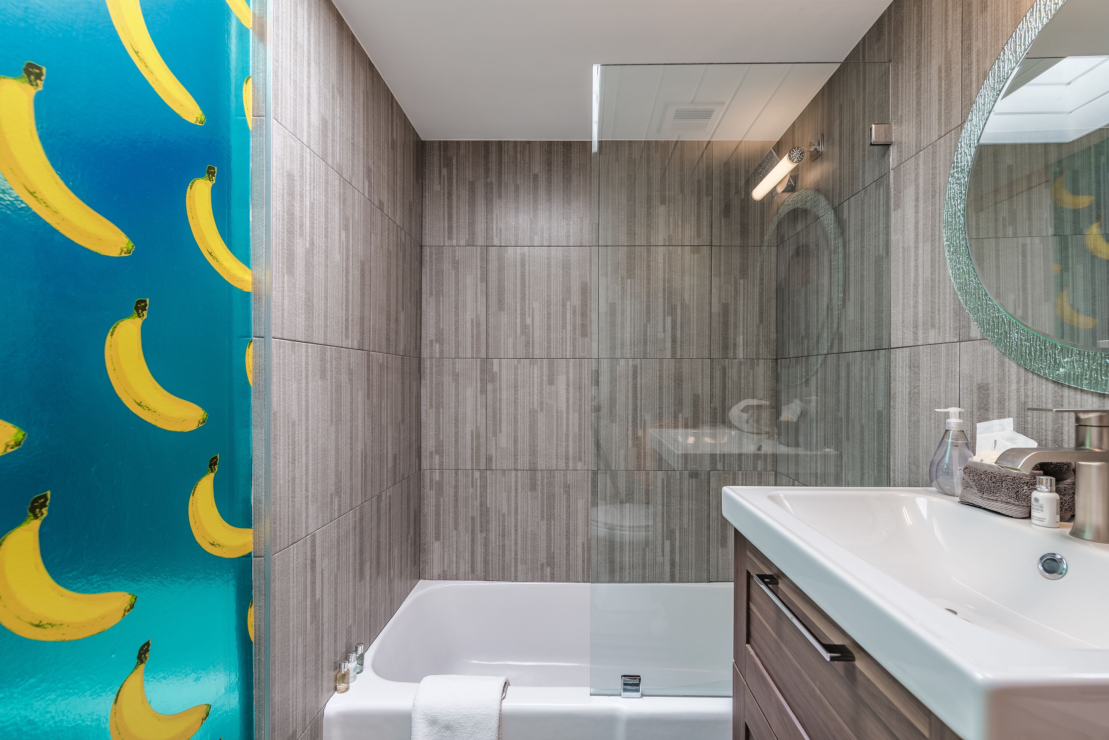 A bathroom with a shower, a bathtub, and a vanity with a mirror.