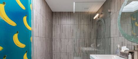 A bathroom with a shower, a bathtub, and a vanity with a mirror.