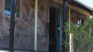 A stone building with a partially open door and a visible window. - Leruk Guest House (Maasai Mara)