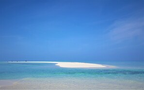 A beach with clear turquoise water and a white sandbar.