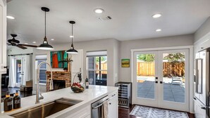 A modern kitchen with a large island, stainless steel appliances, and a view to the backyard.