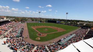 A baseball stadium with a large seating area, a baseball diamond, and a scoreboard.