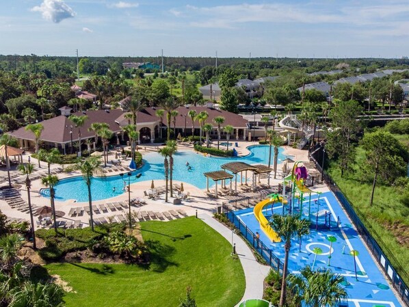 Un resort con múltiples piscinas, un parque acuático y una zona de césped bien cuidada.