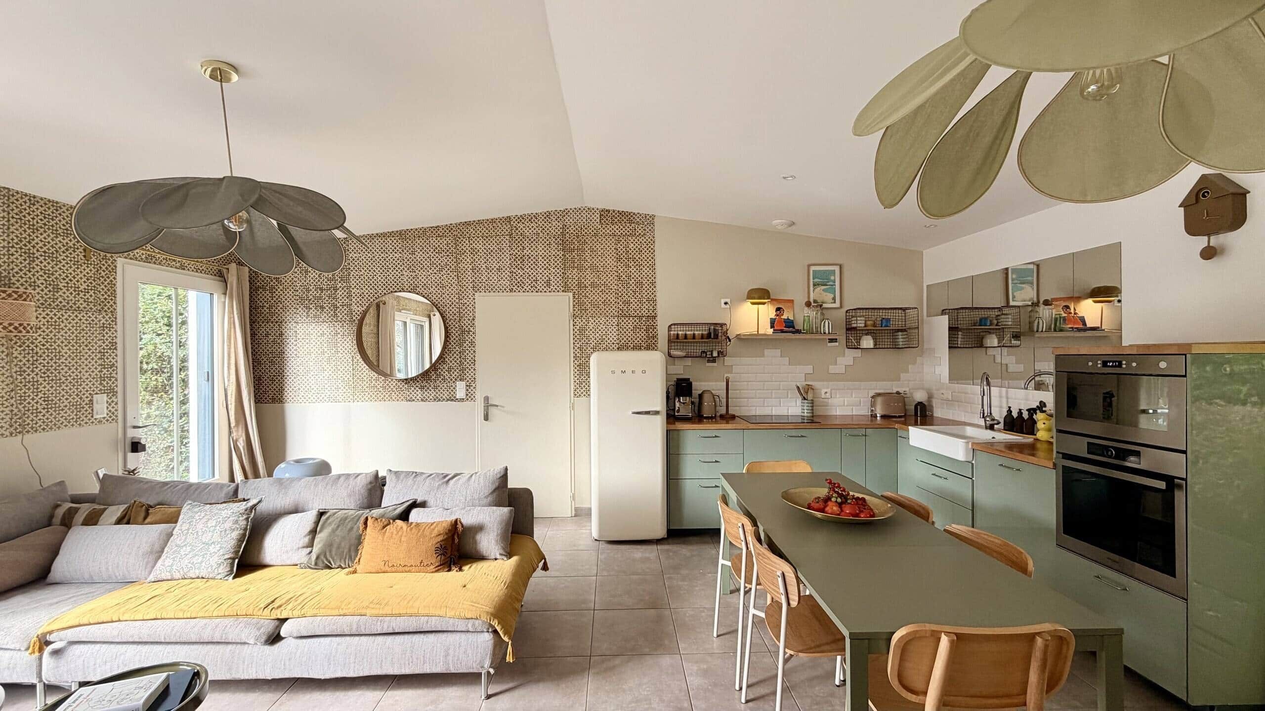 A modern living space with a sofa, dining table, and kitchen area.